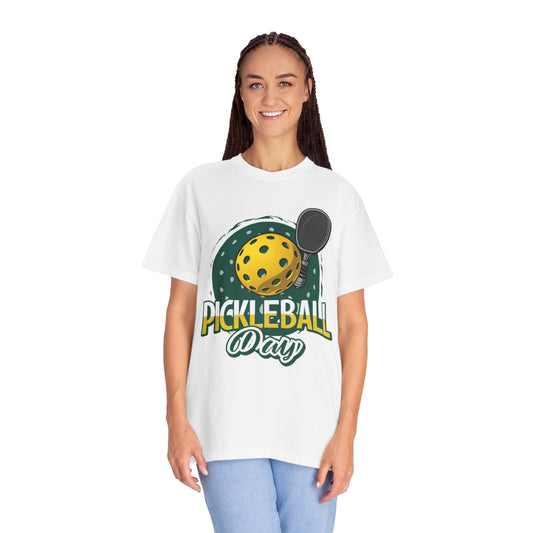 Diseño de celebración del día del Pickleball con una caprichosa ilustración de pelota y paleta - Camiseta unisex teñida en prenda 