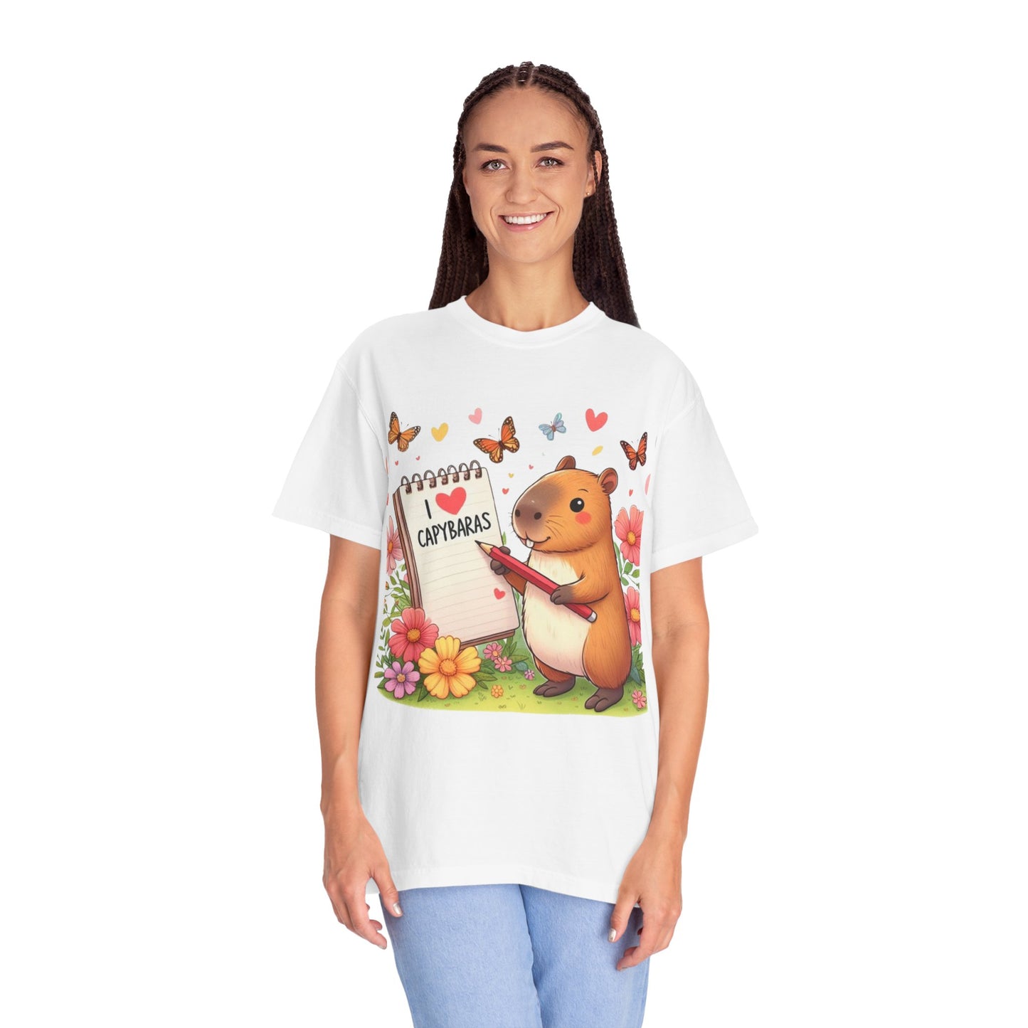 Capibara sosteniendo lápiz y libreta con I Love Capybaras, lindo roedor rodeado de flores y mariposas, camiseta unisex teñida en prenda 