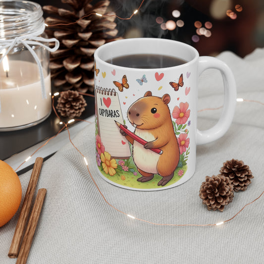 Capybara Holding Pencil and Notepad with I Love Capybaras, Cute Rodent Surrounded by Flowers and Butterflies, Ceramic Mug 11oz