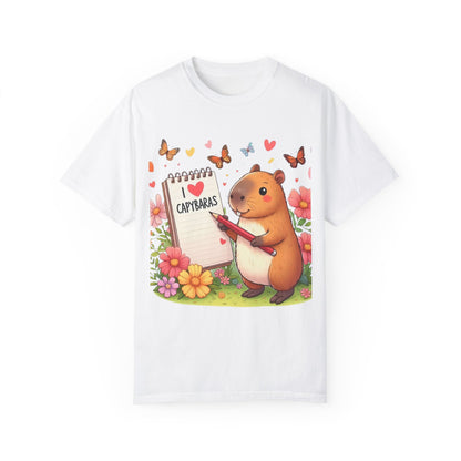 Capibara sosteniendo lápiz y libreta con I Love Capybaras, lindo roedor rodeado de flores y mariposas, camiseta unisex teñida en prenda 