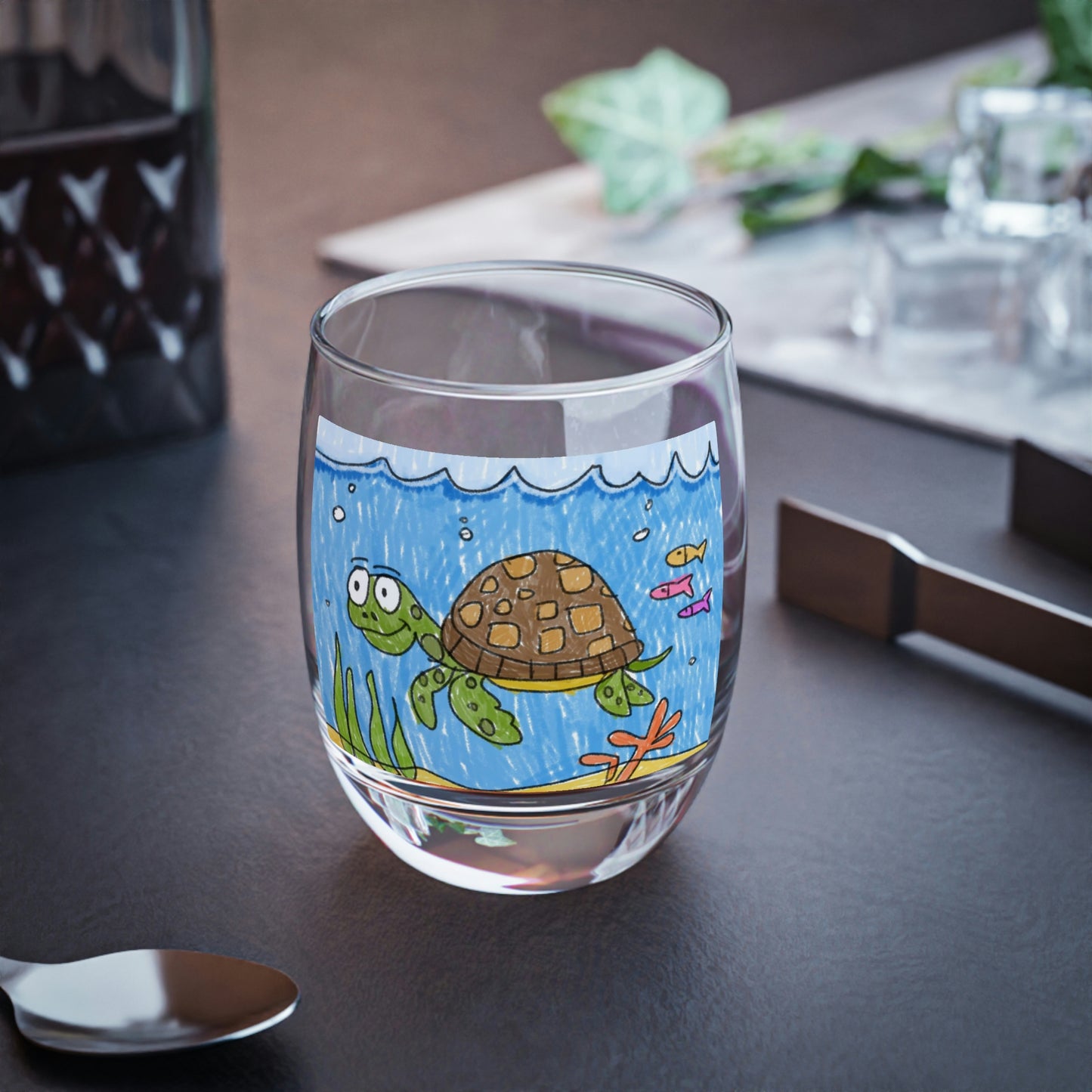 Vaso de whisky con arena de playa y tortuga marina