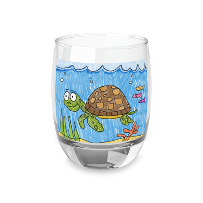 Vaso de whisky con arena de playa y tortuga marina