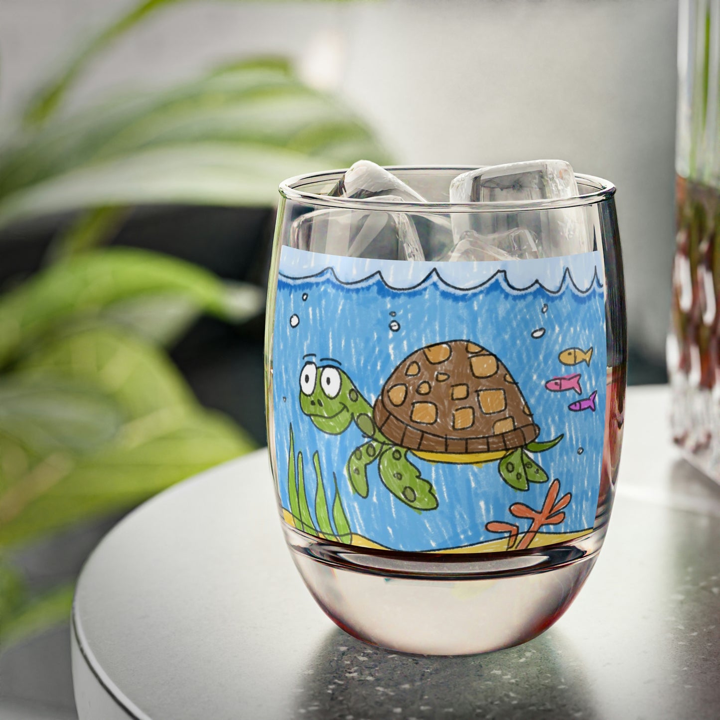 Vaso de whisky con arena de playa y tortuga marina